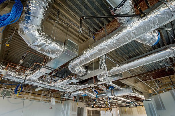 Insulated air ducts being installed in an office building HVAC system.